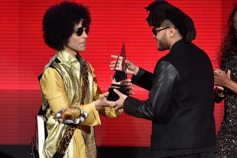 The Weeknd (right) accepts the award from Prince for favorite soul/R&B album for "Beauty Behind the Madness."