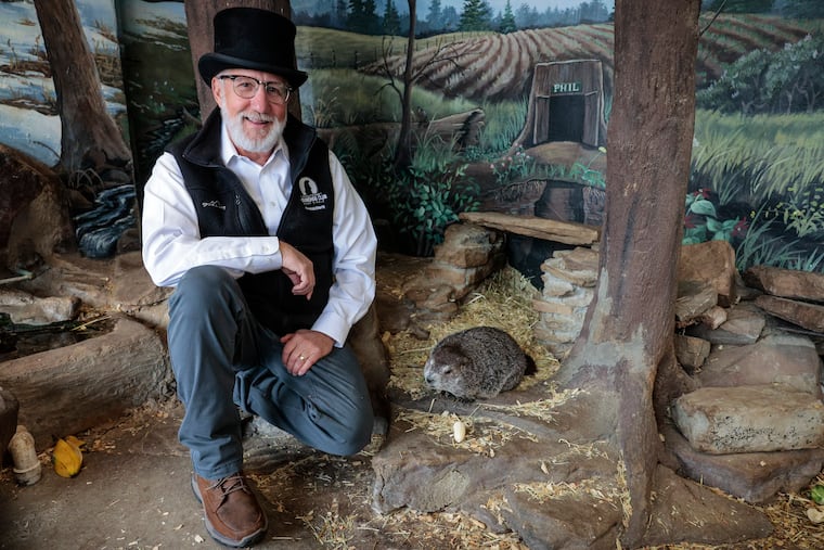 President, Shingle Shaker Tom Dunkel visits Phil at his zoo home at the library in downtown Punxsutawney days before Groundhog Day, Wednesday, Jan. 29, 2025, in Punxsutawney
