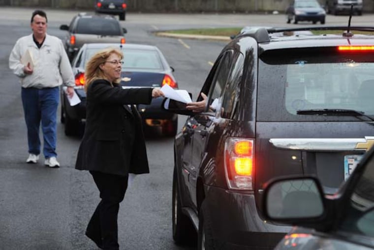 People hand fliers supporting Philadelphia Academic Charter School CEO Larry Sperling to parents dropping their kids off at the school Arpil 4, 2014. The school is dealing with new problems since five board members have either abruptly resigned or been replaced since August. ( CLEM MURRAY / Staff Photographer )
