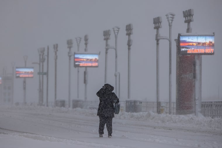 A pedestrian on the boardwalk braces against the snow and wind on Monday.
