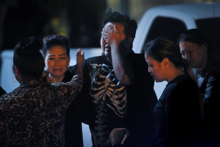 People gather late Sunday evening near the site of a mass shooting in Fresno, Calif.