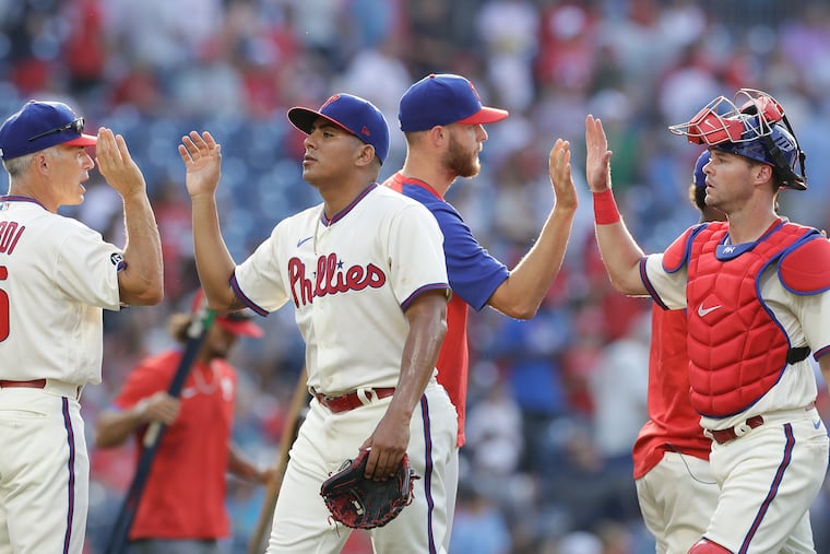 Ranger Suarez, then a reliever, high fives Phillies Manager Joe Girardi as catcher Andrew Knapp high fives pitcher Zack Wheeler after the Phillies beat the Miami Marlins in Game 1 of a doubleheader on Friday, July 16, 2021 in Philadelphia.