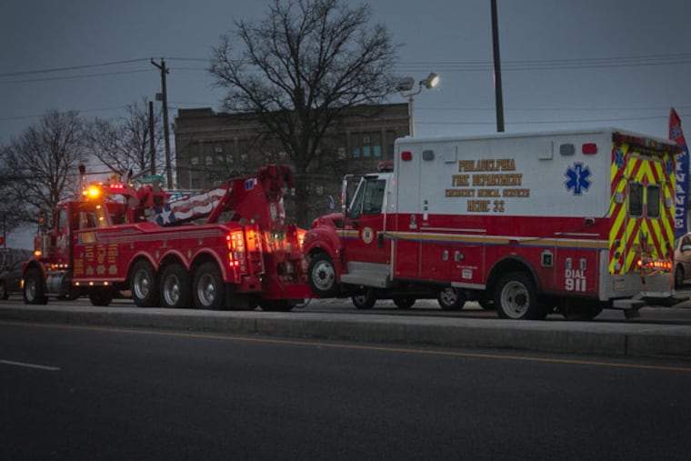 Medic unit with front end dagage is towed from Engine Co. 52 after a car crashed into the Wissinoming firehouse on Friday, Feb. 27, 2015.
