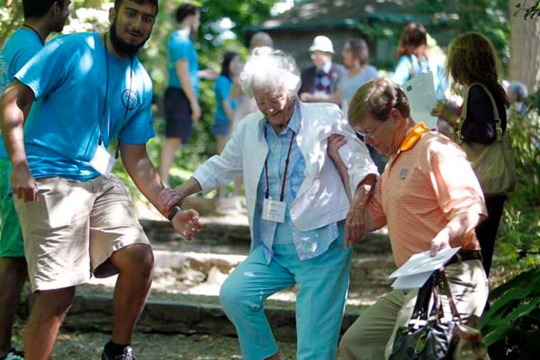 Swarthmore student Ammar Dahoowala (left) and David Williams (son of Louise) (right) helping Louise Williams,100, who is coming down steps to an Amphitheater. 06-07-2014 ( AKIRA SUWA / Staff Photographer )