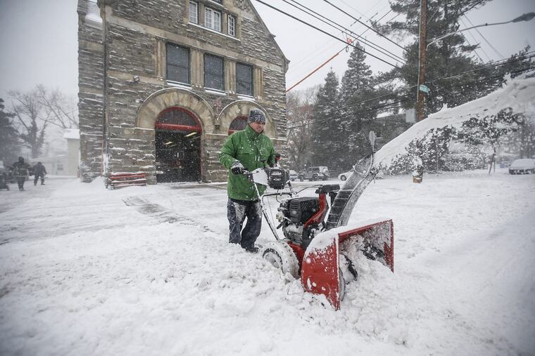 Philadelphia Firefighter Jeffery Kemm, center, uses his snowblower to make sure the driveway to Engine 37 in Chestnut Hill is clear of snow in case they get a call and have to get their firetruck out quickly during the snowstorm on Jan. 4, 2018.