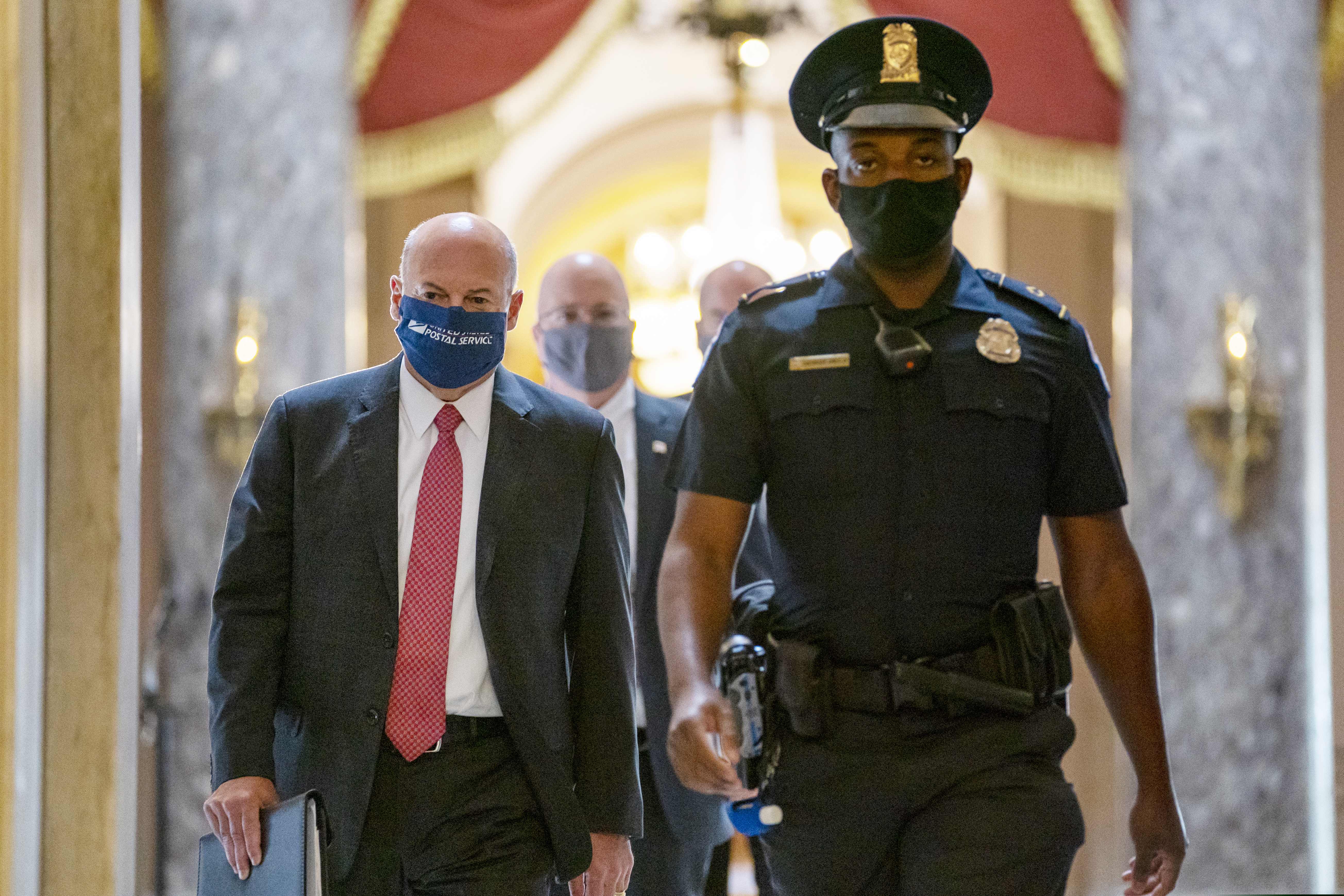 Postmaster General Louis DeJoy, left, shown getting escorted to House Speaker Nancy Pelosi's office on Capitol Hill in Washington on Aug. 5.