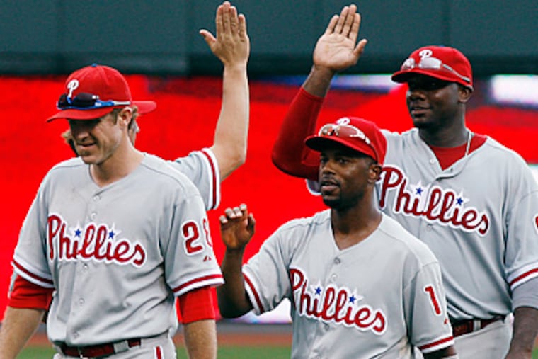 Jimmy Rollins, Chase Utley, and Ryan Howard celebrate after defeating the Cincinnati Reds. (AP Photo/David Kohl)
