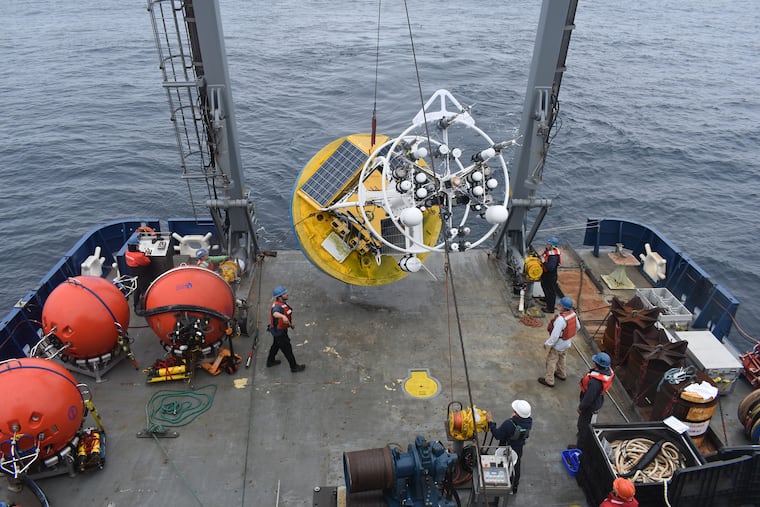 In an image provided by the National Science Foundation Ocean Observatories Initiative, workers recover a surface buoy — part of a network of moorings, buoys, and gliders making observations of the ocean — from the Irminger Sea off Greenland’s coast, in 2021. The Trump administration is dismantling a $368 million deep-ocean observation system that monitors marine ecosystems and the effects of climate change.