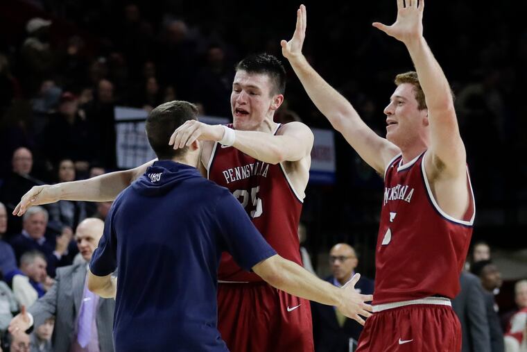 Penn forward AJ Brodeur (center) hugs teammate forward Max Rothschild (left) as guard Jake Silpe raises his arms after Penn beat St. Joe's 78-70 for the Big-5 title at The Palestra on Saturday, January 26, 2019.