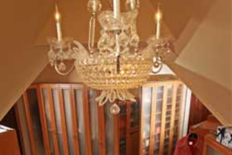 Nancy Gansky and her dog, Nutmeg, relax on an ottoman under the chandelier in the 300-square-foot closet in her Fort Washington home.