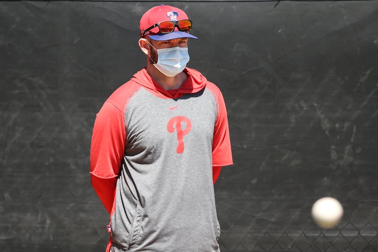 Phillies first-year pitching coach Caleb Cotham watches Zack Wheeler warm up in the bullpen before Sunday's game against the New York Yankees in Tampa, Fla.