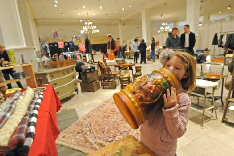 Erin Murphy, 6, of Ardmore, browses at the Franklin Flea market in the old Strawbridge & Clothier store on Market Street.