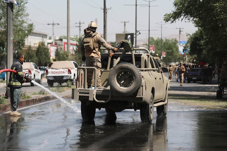 In this June 6, 2021, photo, Afghan security personnel leave the scene of a roadside bomb explosion in Kabul, Afghanistan. The U.S. withdrawal from Afghanistan is more than half done, and U.S. officials say that while it could be completed by July 4, the final exit of equipment and troops more likely will be later in the summer.