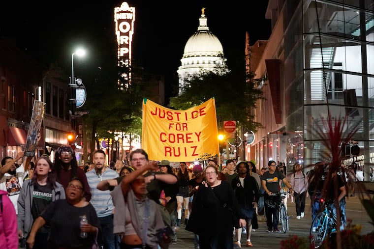 Protesters march past the Wisconsin state capitol building in Madison, a day after a police officer shot and killed Corey Ruiz.