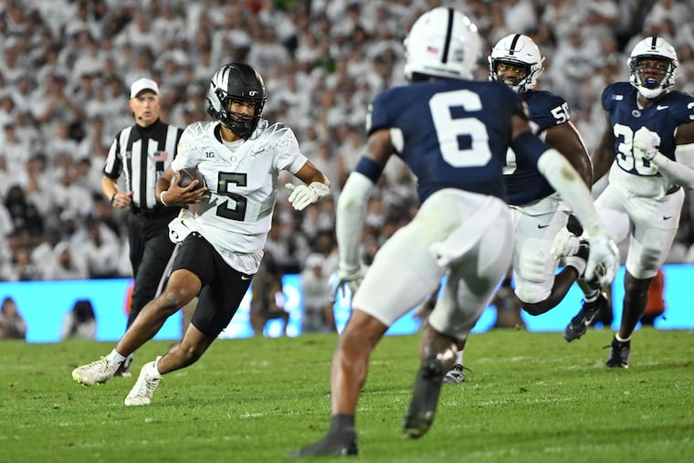 Oregon quarterback Dante Moore looks to elude Penn State safety Zakee Wheatley (6) during the first quarter Saturday night in State College, Pa.