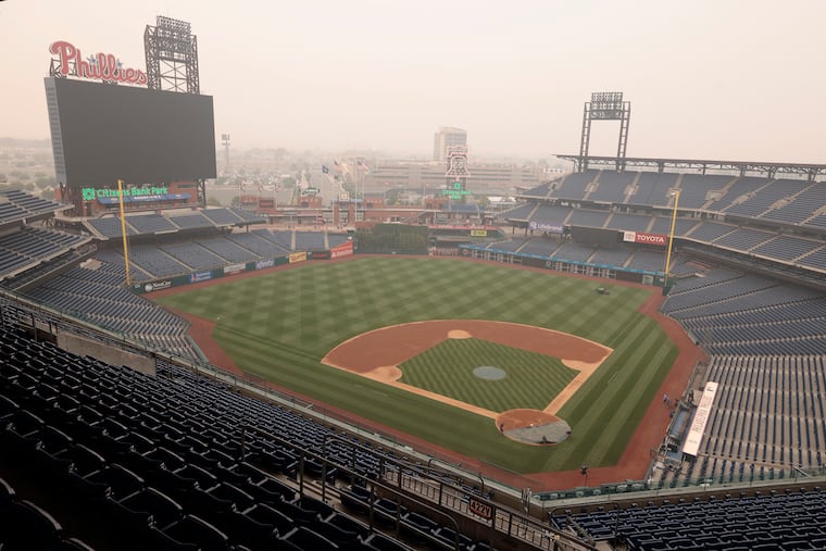 Phillies grounds crew employees put a tarp over the home plate area at Citizens Bank Park on Wednesday. The Phillies are scheduled to face the Detroit Tigers Thursday at 6:05 p.m.