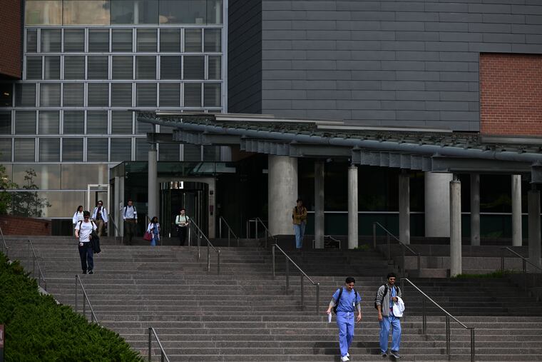 People walk down the stairs of the University of Cincinnati College of Medicine in Cincinnati. Ohio Gov. Mike DeWine banned DEI training and offices in March, calling for the end of race-based scholarships. MUST CREDIT: Joshua Lott/The Washington Post