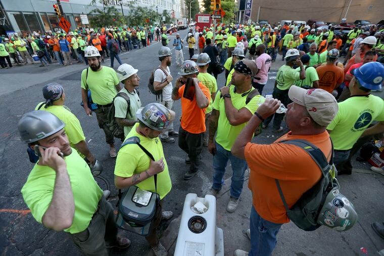 Union workers gather outside the construction site as crane operators protest in front of the Comcast tower.