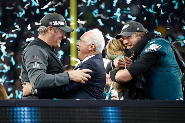 Eagles owner Jeffrey Lurie (center) fired coach Doug Pederson, left, and watched Nick Foles play for two other teams since their Super Bowl LII win three years ago.