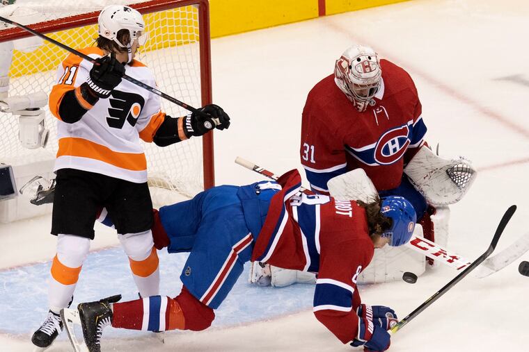 Montreal defenseman Ben Chiarot (8) gets leveled by Flyers right winger Travis Konecny (11) as Canadiens goaltender Carey Price makes a save during a recent playoff game. Konecny is goal-less in nine postseason games.