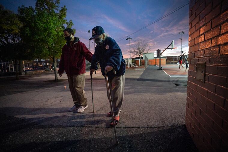 An elderly voter, center, leaves the polling place at Barry Playground with a companion after voting, in South Philadelphia, on Election Day Tuesday.