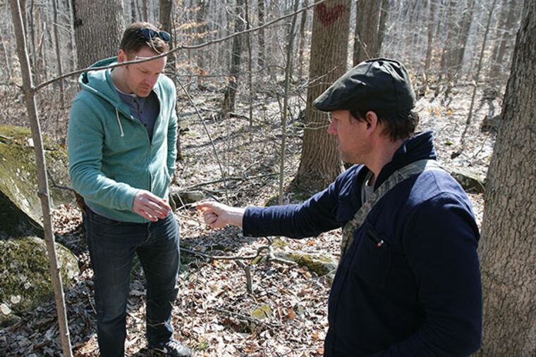 Chef Eli Kulp, left, samples a Trout Lily that professional forager, Evan Strusinski, right, collected as they were foraging along a trail in Hopewell, NJ, on April 9, 2014. Kulp was named one of Food & Wine's Best New Chefs and cooks at Fork, High Street Market and a.kitchen. ( DAVID MAIALETTI / Staff Photographer )