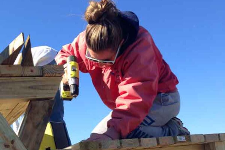 Island Beach State Park lifeguard Megan Klaslo, 25, of Toms River, works on one of a dozen lifeguard stands built to replace those damaged or swept away in the storm. Staff photo by Julia Terruso