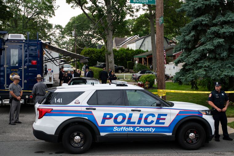 Police officers stand guard near the house where a suspect was taken into custody on Long Island in connection with a long-unsolved string of killings, known as the Gilgo Beach murders.