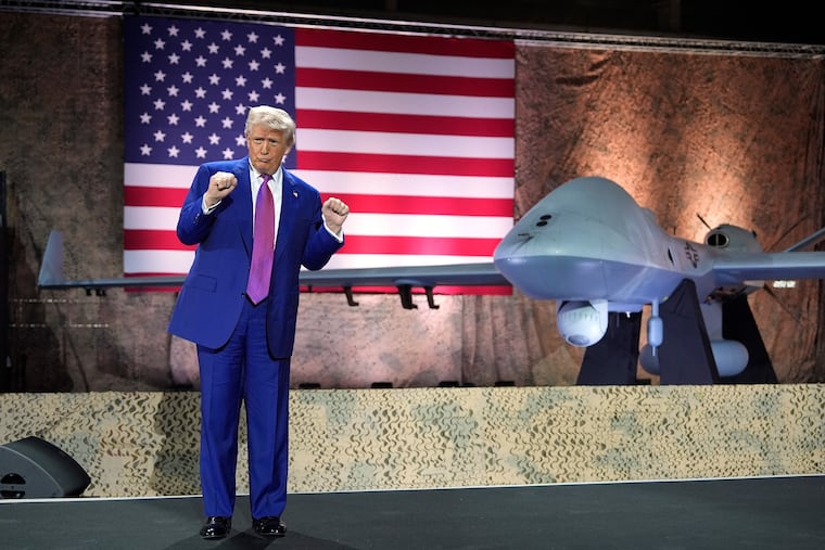 President Donald Trump gestures backdropped by an MQ-9 Reaper drone at the Al Udeid Air Base, Thursday, May 15, 2025, in Doha, Qatar. Officials say the U.S. has lost about 25% of its fleet of the drones in the Iran war.