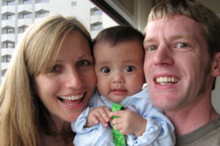 Meghan and Michael Wall hold Eddy, the infant they want to adopt, during a visit to Guatemala. They hoped to get him this month, but, like hundreds of other prospective parents, are still waiting.