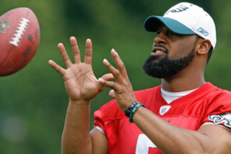 Eagles quarterback Donovan McNabb tries his hand at catching the ball at the full-squad minicamp.