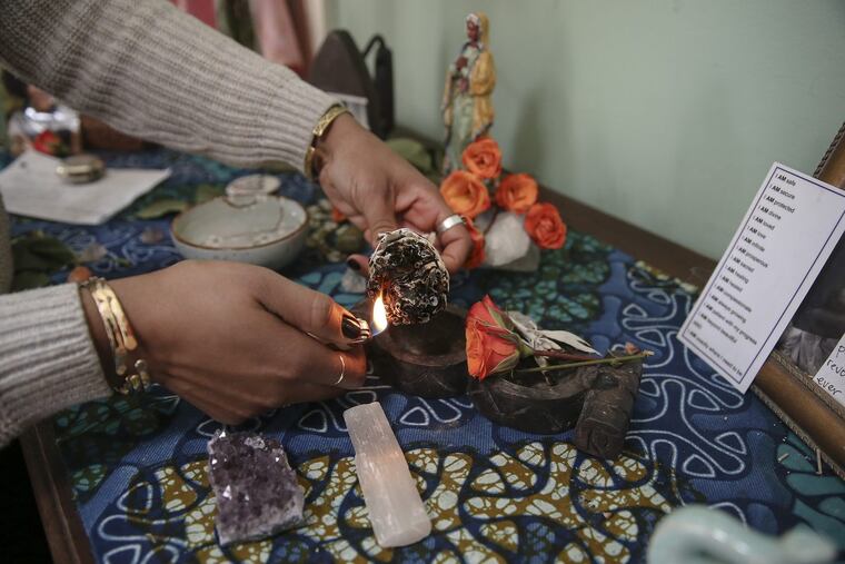 Shanti Mayers at the alter in her home saging her room.