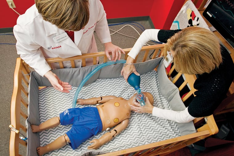 At Bayada in Mount Laurel, Heather Kuzara (left) uses a simulator to teach a procedure to Stacy Tuttle (right), who cares for a severely disabled son.