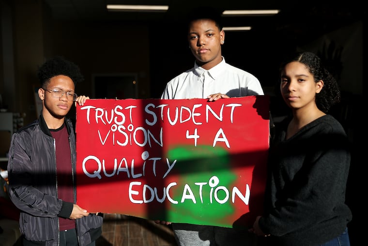 From left, Science Leadership Academy at Beeber senior Amir Curry, 18; Workshop School sophomore Charles Mitchell, 16; and Academy at Palumbo senior Nayeli Perez, 18, stand with one of their signs at the Philadelphia Student Union office in West Philadelphia. They are preparing to testify before the school board against a policy mandating the use of metal detectors in all Philadelphia School District high schools.