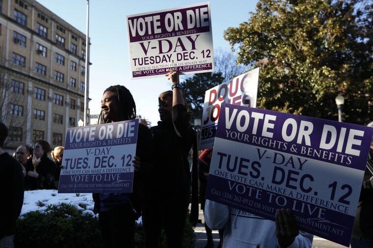 Supporters stand outside encouraging for people to vote after Democratic senatorial candidate Doug Jones spoke at a campaign rally Sunday in Birmingham.
