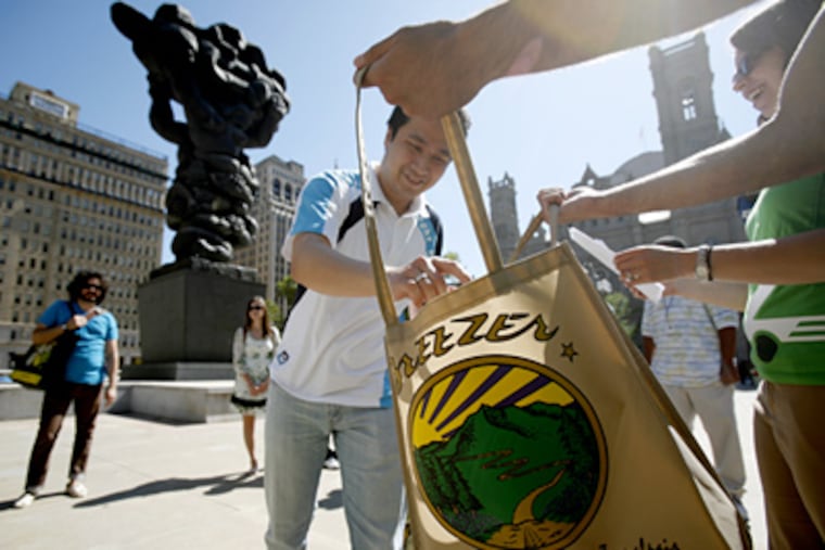 Yosia Handoko drops his car keys into a bag and pledges to give up his car for 30 days. "It'll force me to think about what I'm doing," said another program participant. (Eric Mencher / Staff Photographer)