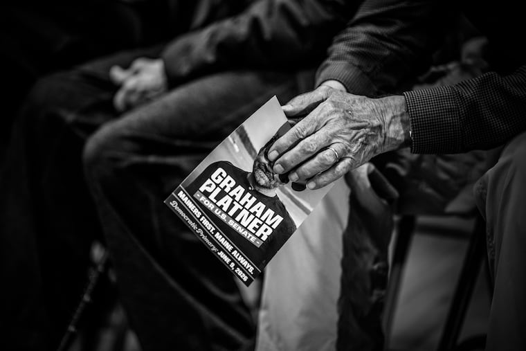 FILE — An attendee holds a campaign flyer for Graham Platner, a veteran who is running for the Democratic nomination for the Senate in Maine, during Platner’s town hall in Boothbay Harbor, Maine, April 12, 2026.