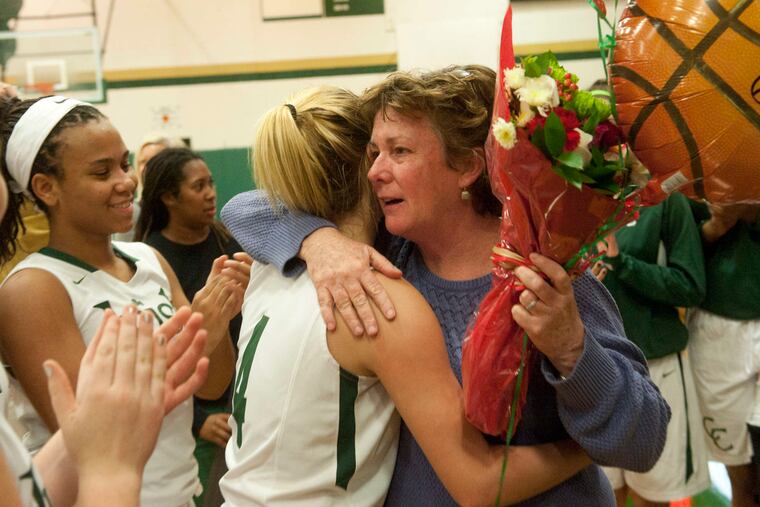 Camden Catholic girls' coach Chris Palladino hugs a player as she celebrates her 600th coaching victory. Palladino is in her 32d year at the helm. A packed house watched the opener.