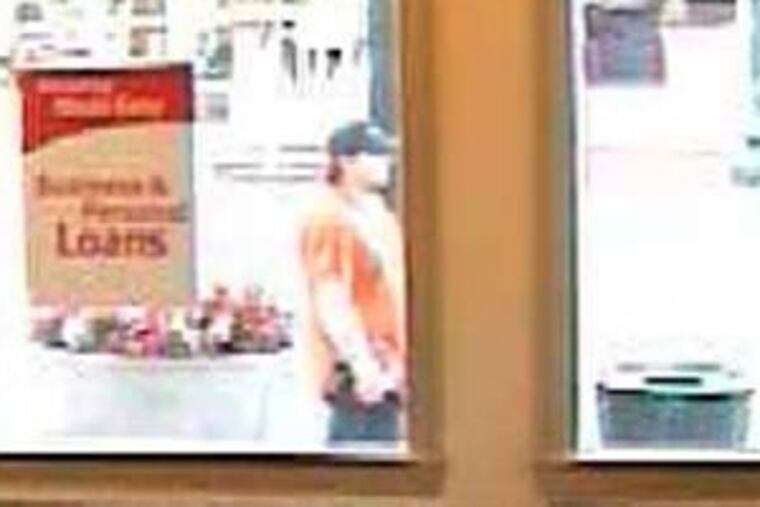A surveillance photograph from a West Chester bank shows a "person of interest" in the garage bomb case.