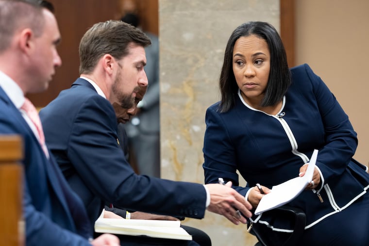 Fulton County District Attorney Fani Willis, right, talks with a member of her team during proceedings to seat a special purpose grand jury in Fulton County, Georgia, oin May, to look into the actions of former President Donald Trump and his supporters who tried to overturn the results of the 2020 election.