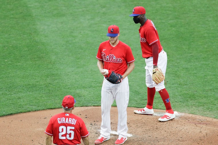 Phillies pitcher Zack Wheeler waits for manager Joe Girardi to take him out of the game as shortstop Didi Gregorius looks on during Sunday's exhibition game at Citizens Bank Park.