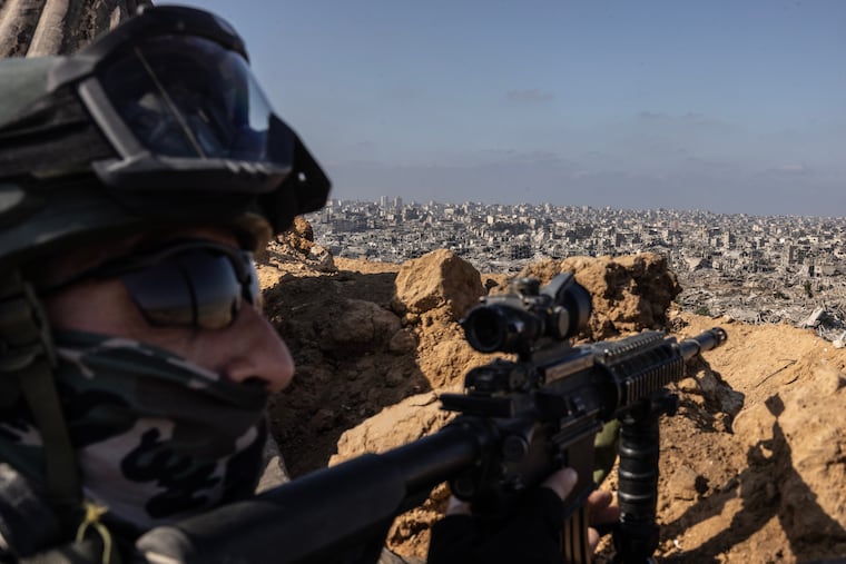 An Israeli soldier at an IDF outpost aims his weapon toward Gaza City in October 2025.