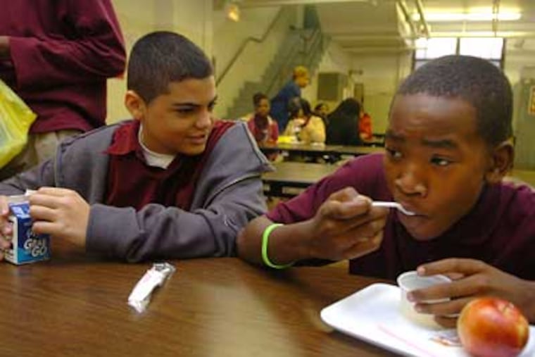 Students Joseph Olivo, left, and Jamere Preston eat lunch at Laura Waring Elementary School. Sen. Arlen Specter and other politicians are disappointed that the USDA will teminate an important school meal program in the School District of Philadelphia. (Sarah J. Glover / Staff Photographer)