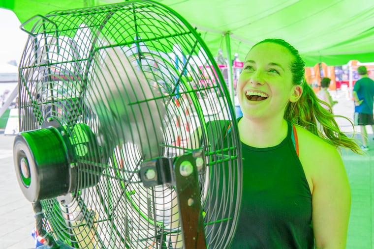 Standing in front of one of the many fans in the workout tents, Julie Cohen cools off after her Fit Camp workout, part of the Wawa Welcome America festivitites, at the foot of the Philadelphia Art Museum steps Sunday.