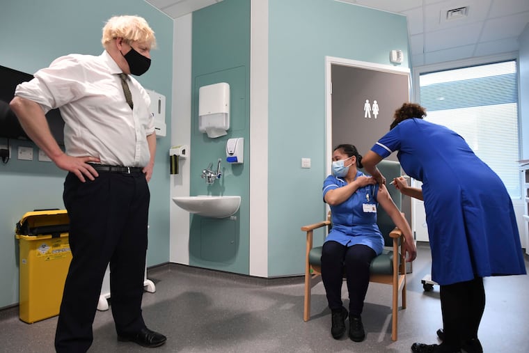 Britain Prime Minister Boris Johnson watches as nurse Jennifer Dumasi is injected with the Oxford-AstraZeneca Covid-19 vaccine during a visit to view the vaccination program at the Chase Farm Hospital in north London on Monday.