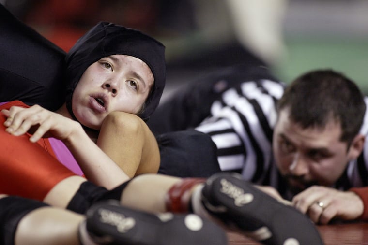 Action in the girls' wrestling state championships in Washington, one of 10-12 states that offer the sport.