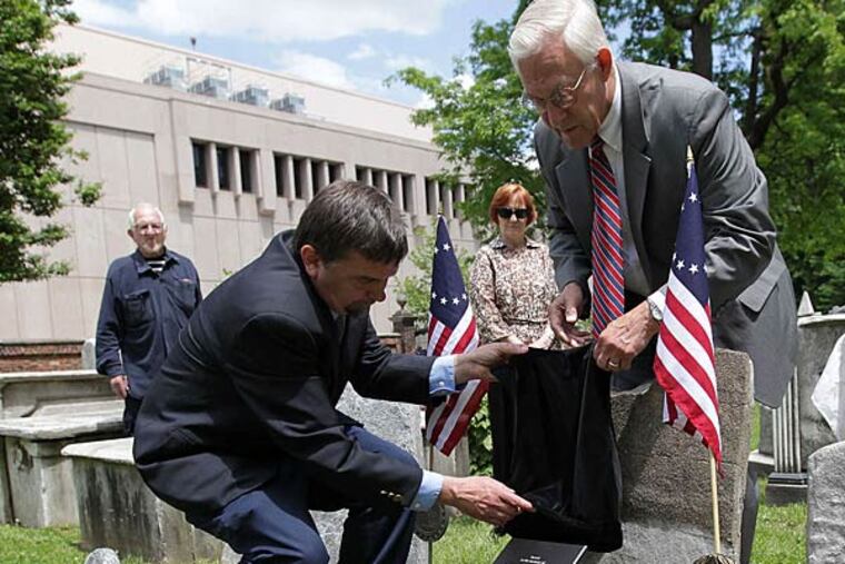 John Hopkins (left) and Allan Hasbrouck unveil the plaque at the burial ground. Hasbrouck is a former Inquirer editor.