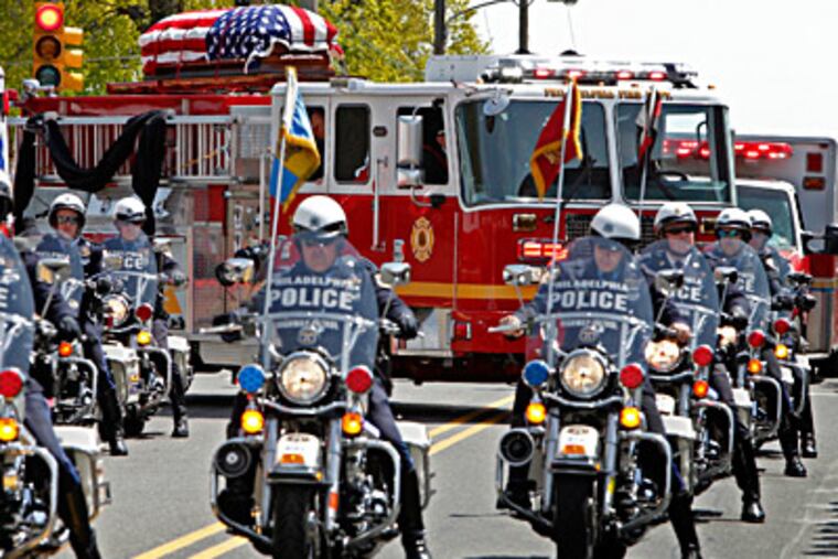 Philadelphia Highway Patrol officers lead Engine 7, which bore the casket of Firefighter Daniel Sweeney from St. Cecilia Roman Catholic Church on Rhawn Street. ALEJANDRO A. ALVAREZ / Staff Photographer