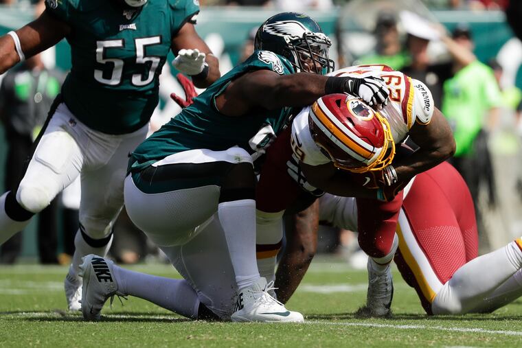 Washington running back Derrius Guice gets stopped Eagles defensive tackle Fletcher Cox with defensive end Brandon Graham during the third-quarter on Sunday. Guice and the Redskins had three rushing yards total in the second half.