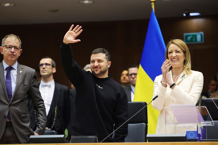 Ukrainian President Volodymyr Zelenskyy waves as European Parliament's President Roberta Metsola (right) applauds during an EU summit in Brussels, Belgium, on Thursday.